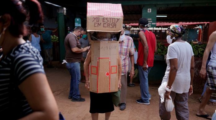 Retired nurse Feridia Rojas, 82, wears cardboard shaped into a house at a market to protect herself from the spread of the coronavirus disease (COVID-19) outbreak, in Havana, Cuba,
