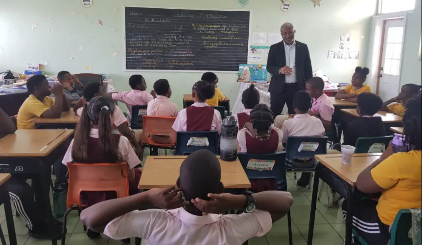Minister Brand with the students of St. Thomas’ Primary School. (Credits: Hon Spencer R Brand, Facebook)